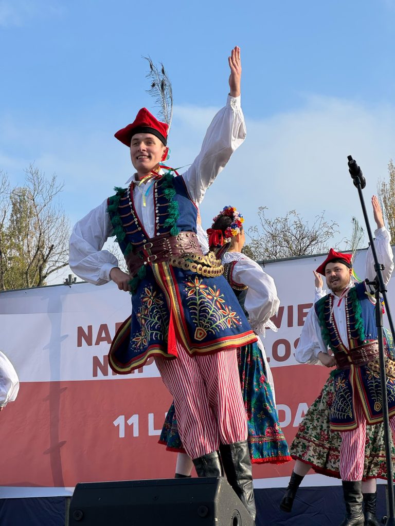 Tancerze w strojach krakowskich w trakcie występu na scenie