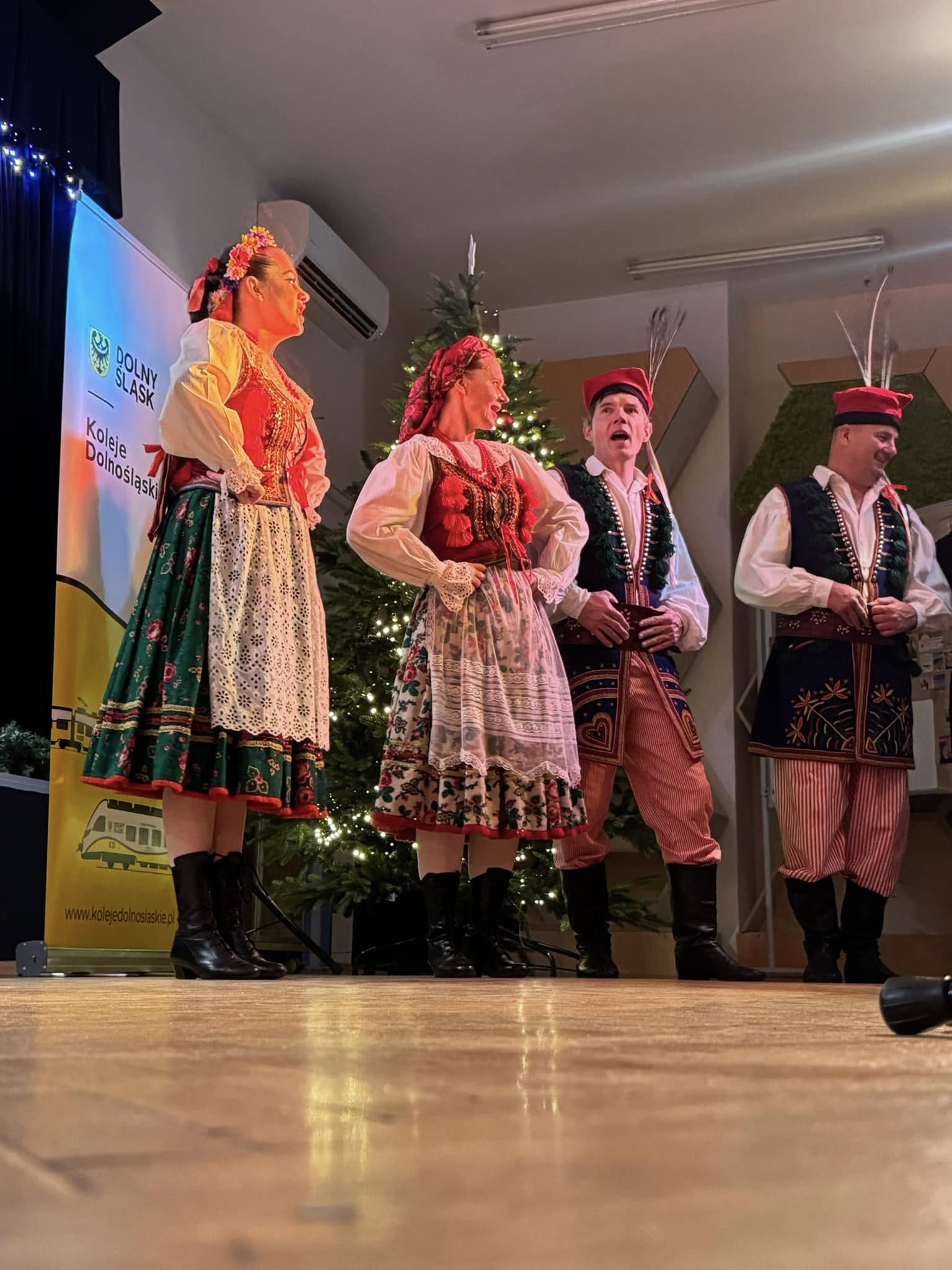 grupa wokalna w strojach krakowskich na scenie