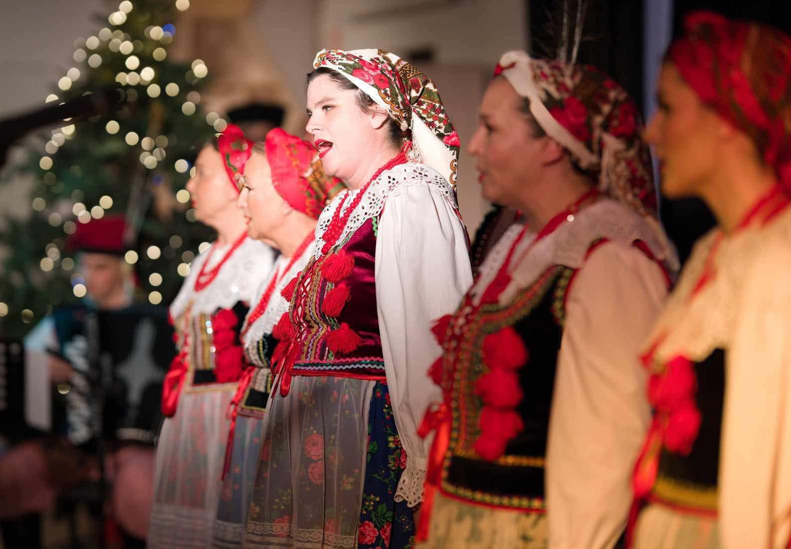 grupa wokalna w strojach krakowskich na scenie - wyostrzenie na solistkę