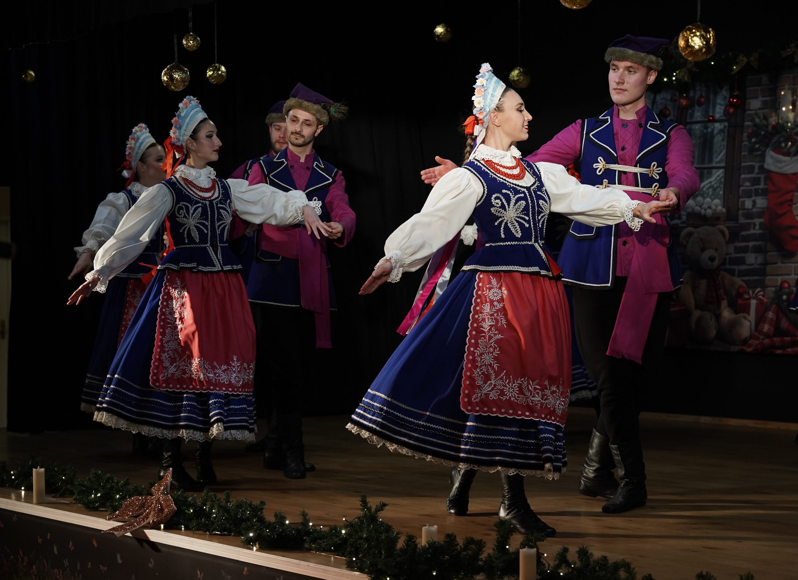 tancerze na scenie w oprawie świątecznej w strojach kujawskich