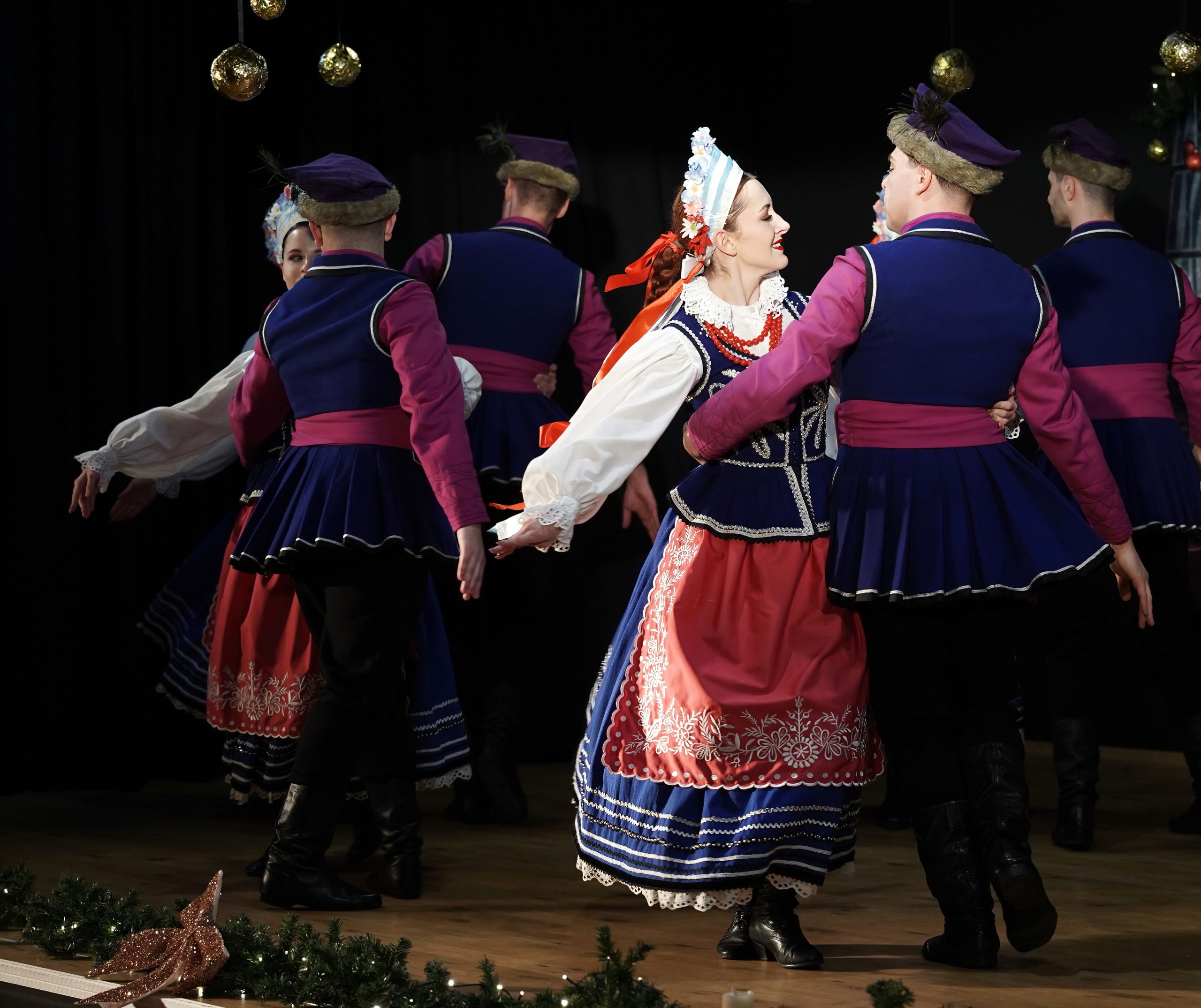 tancerze na scenie w oprawie świątecznej w strojach kujawskich
