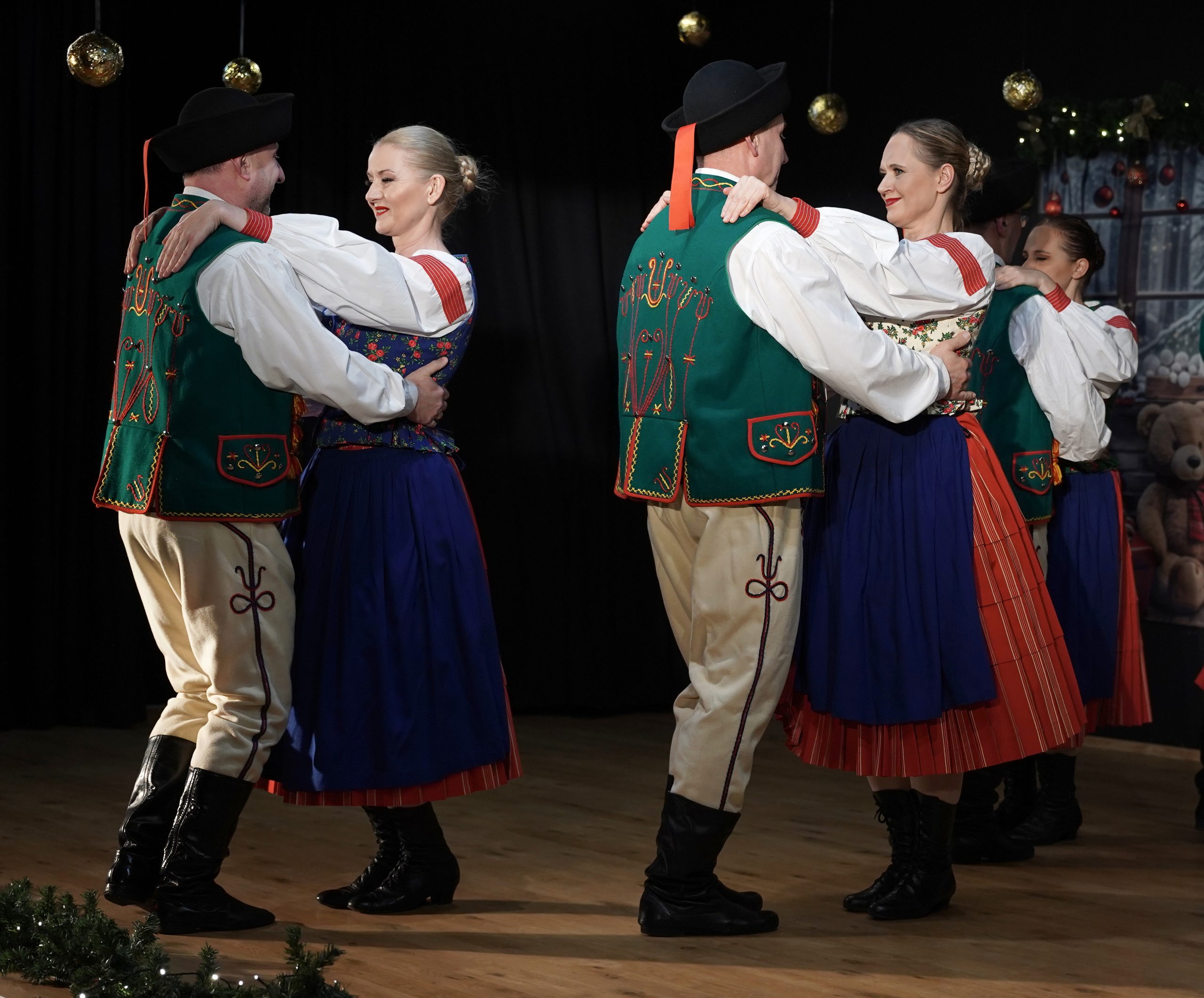 tancerze na scenie w oprawie świątecznej w strojach spiskich