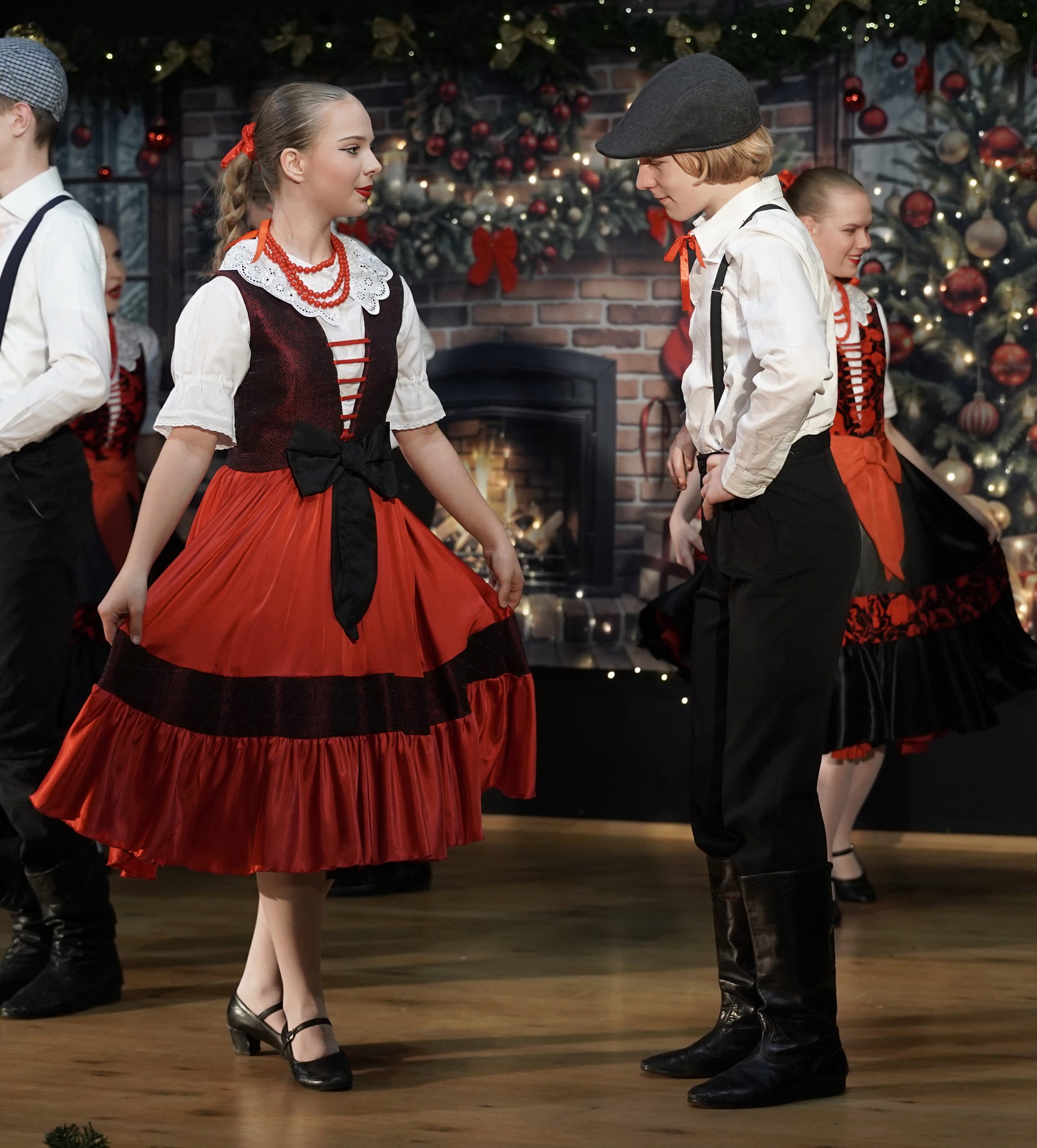 młodzież w strojach warszawskich tańczą wiązankę warszawską na scenie w oprawie świątecznej