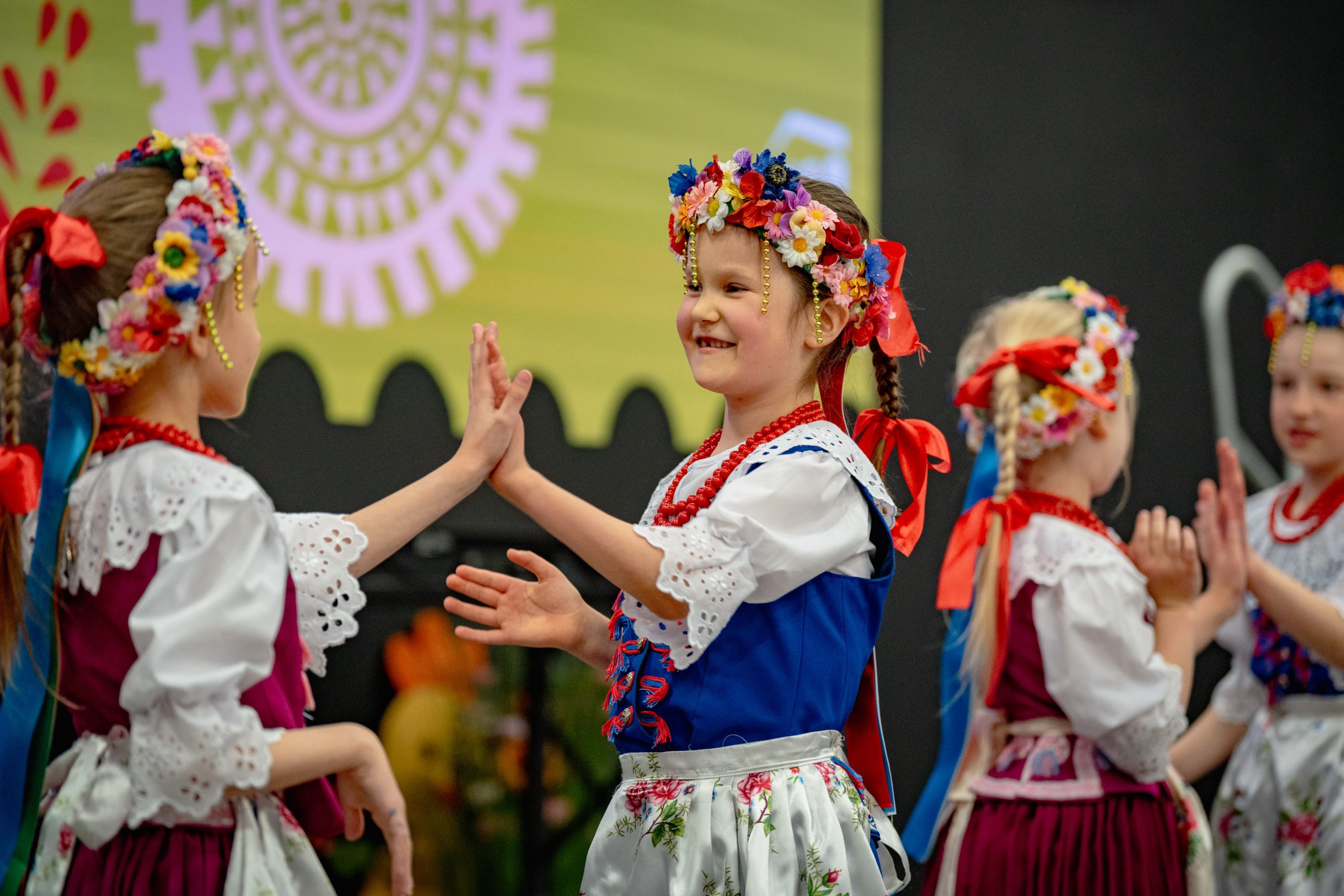 dziewczynki w strojach górnośląskich w wiązance górnośląskiej tańczą klapoka