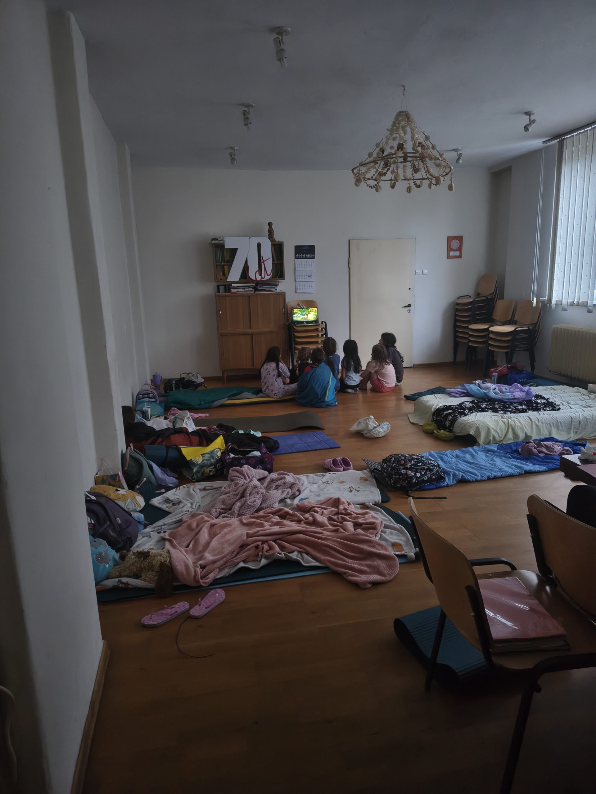 mała sala z rozłożonymi siedziskami z koców, przygotowana pod wieczorny seans